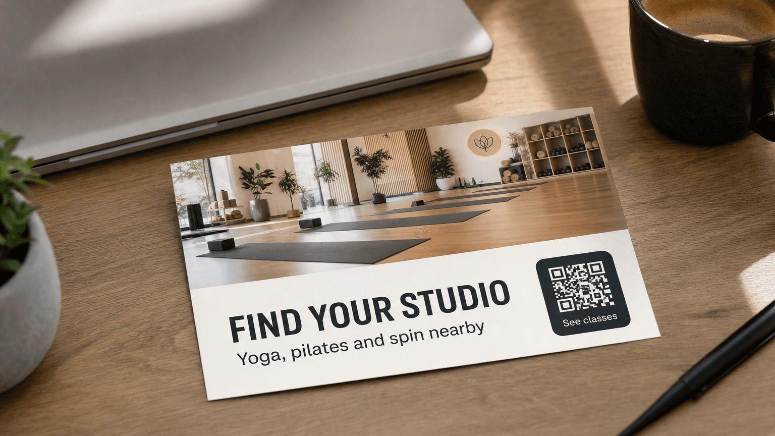 A boutique studio postcard reading 'Find Your Studio' with a yoga and pilates studio photo, on a desk.